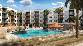 A pool surrounded by chairs and umbrellas in front of apartment buildings.
